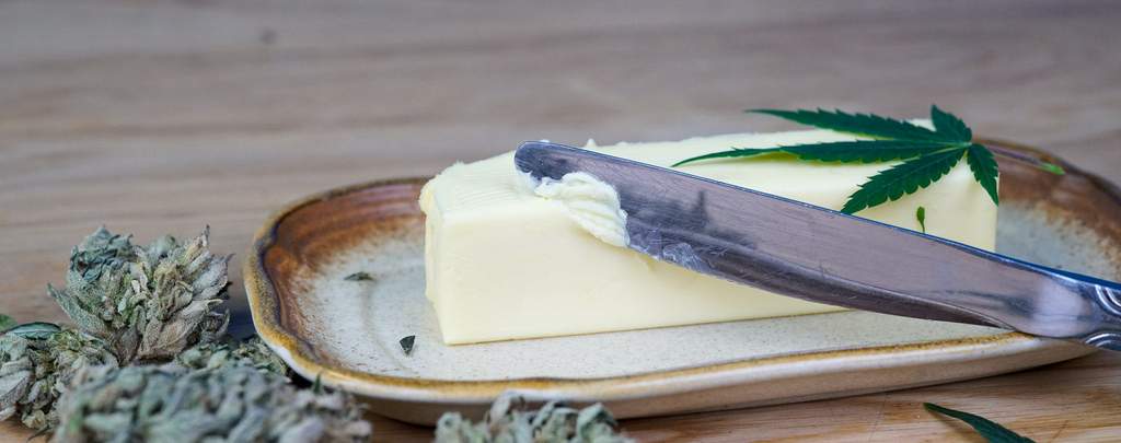 homemade cannabis butter on a butter dish being swiped with a butter knife